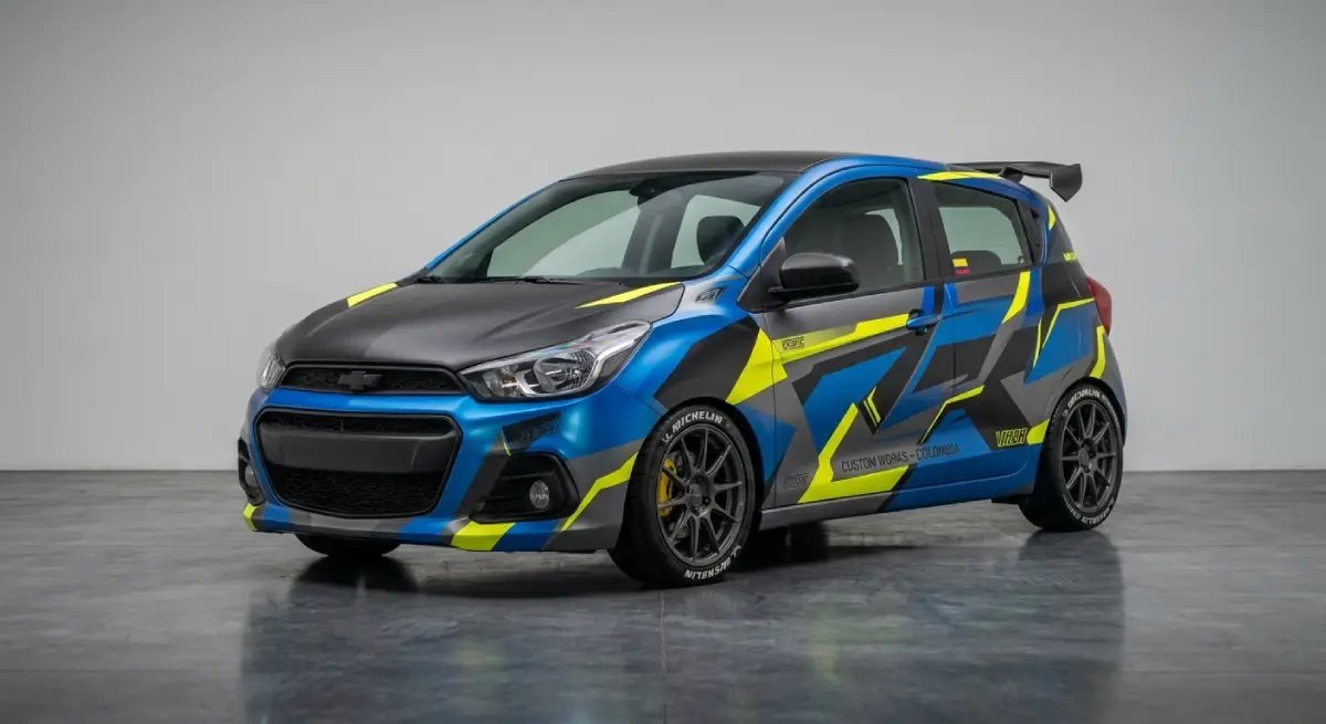 Un automóvil compacto de color azul con gráficos decorativos en amarillo y negro estacionado en un estudio